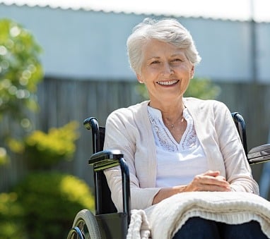 a woman in a wheelchair with a blanket on her